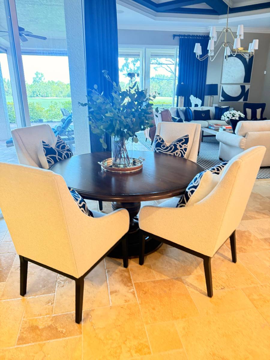 Styled interior dining area with round table and living room beyond