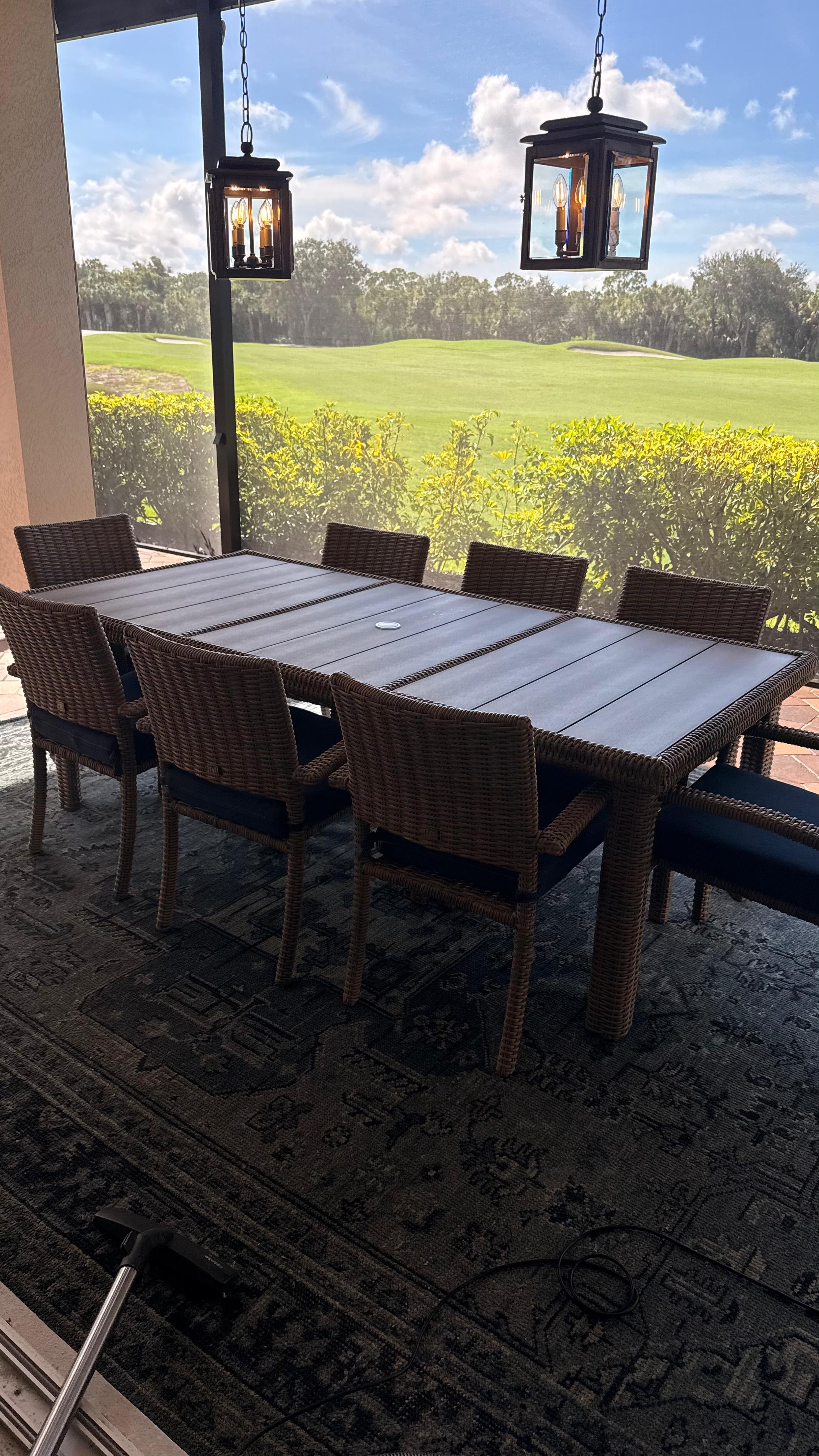 Screened lanai dining table and wicker chairs cleaned, overlooking a golf course