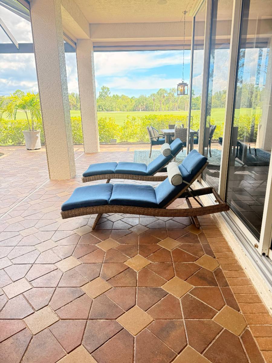Two clean lounge chairs on a terracotta tile lanai