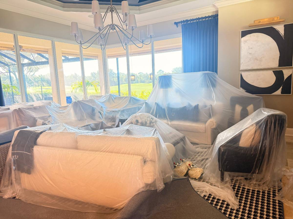 Living room furniture wrapped in protective plastic sheeting