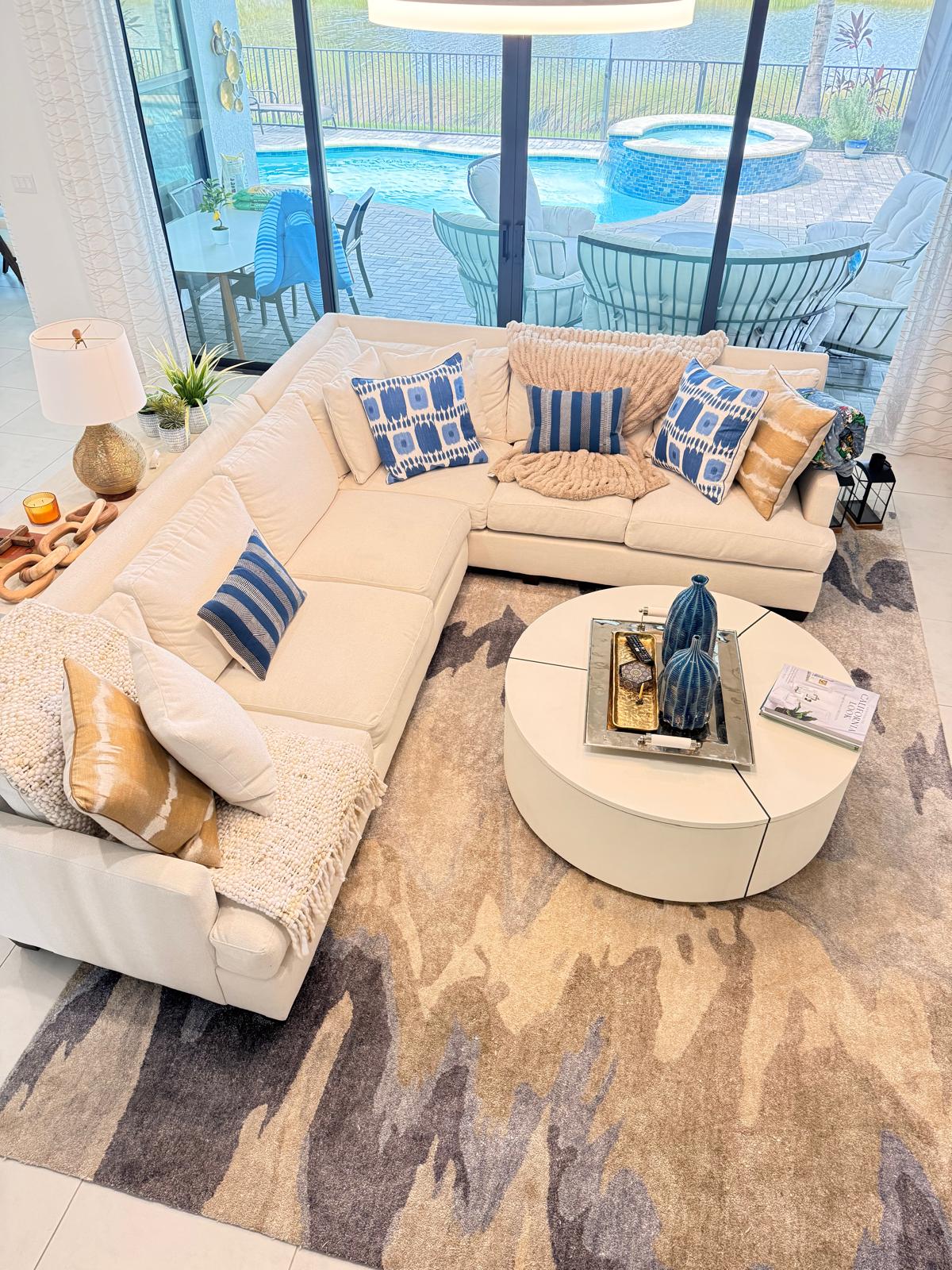 Clean, styled living room with sectional sofa facing the pool