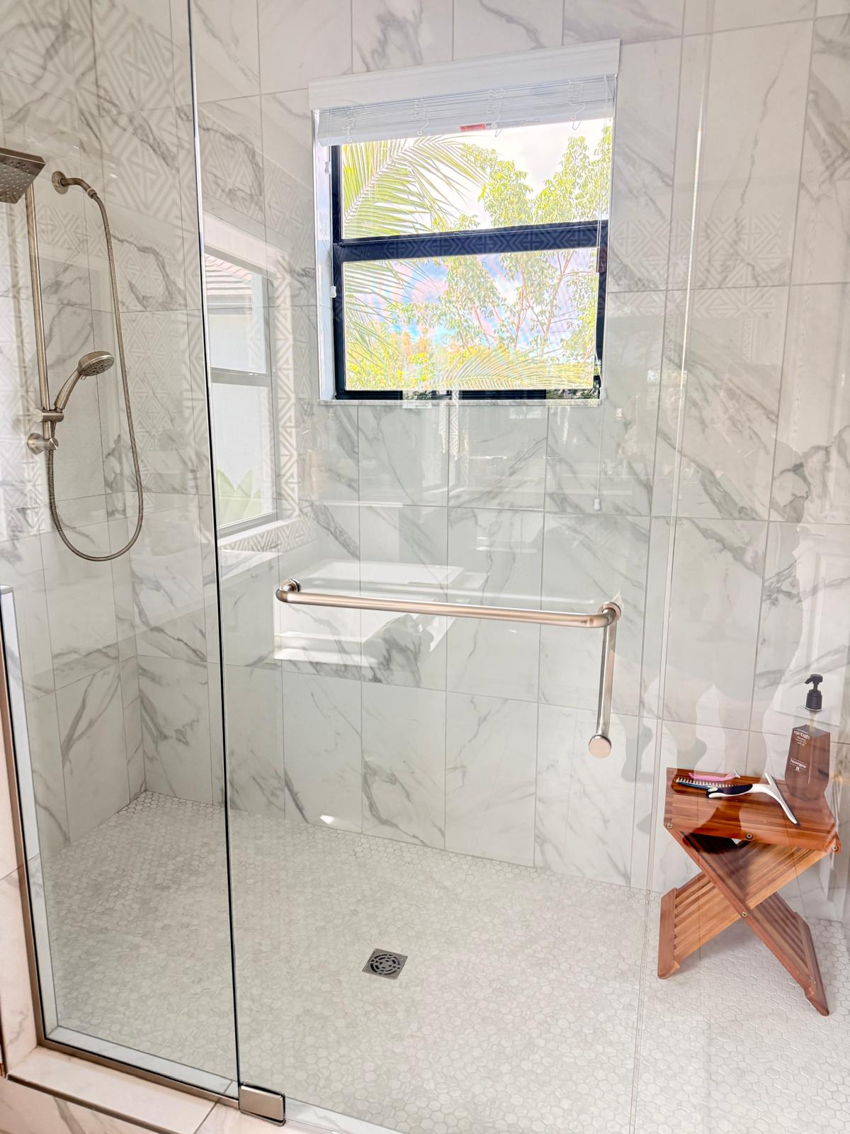 Spotless walk-in marble shower with clear glass
