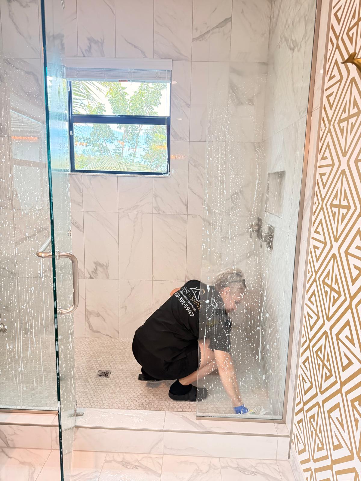 Rise and Shine cleaner scrubbing a marble shower floor