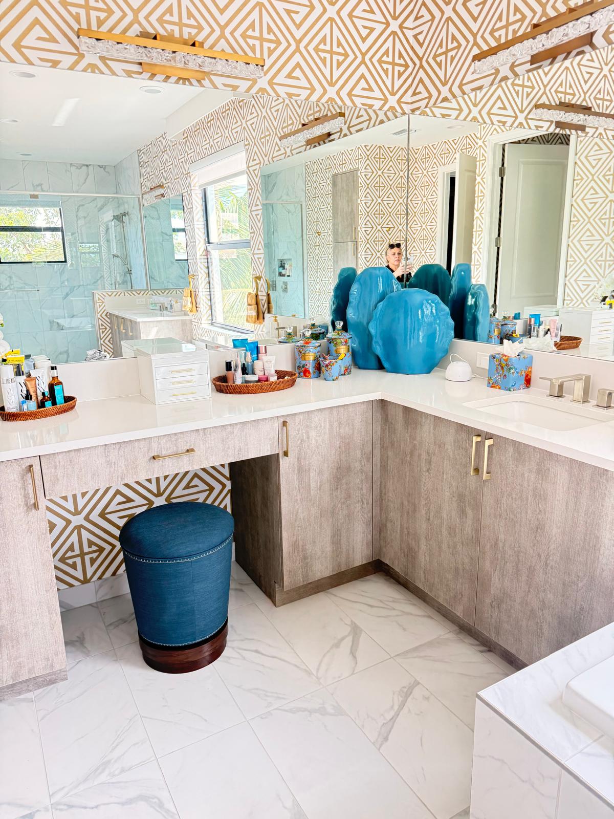 Clean bathroom vanity with marble floor and gold wallpaper
