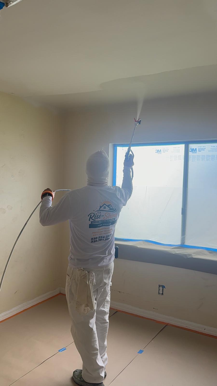 Rise and Shine painter spraying a ceiling with an airless sprayer